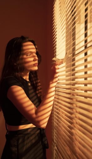 beautiful-young-woman-window-blinds